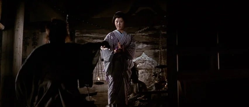 Lone Wolf and Cub: Baby Cart in the Land of Demons (1973) movie still: medium — A dimly lit room contains wooden structures and hanging metal scales…