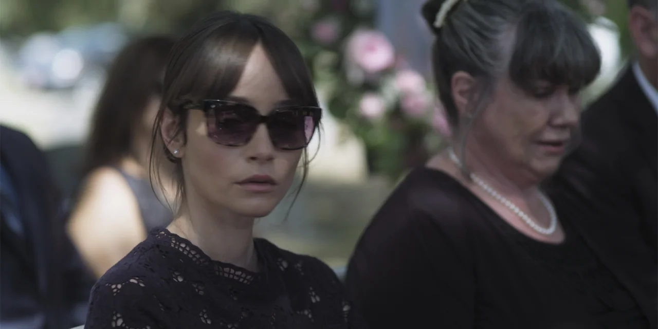 Stalked by My Doctor: A Sleepwalker's Nightmare (2019) movie still: medium — Two women sit together in an outdoor area decorated with flowers. The…