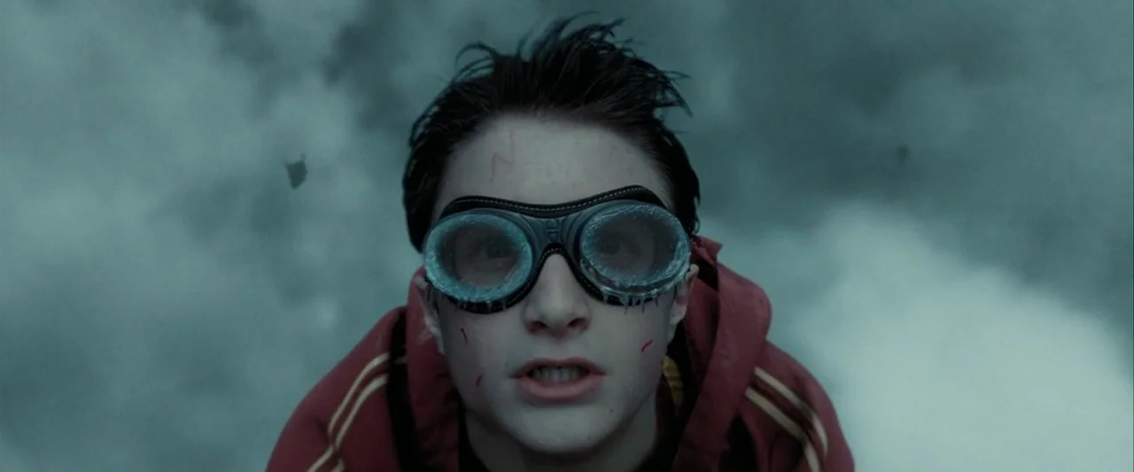 Harry Potter and the Prisoner of Azkaban (2004) movie still: closeup — A person flies through a dense, overcast sky filled with swirling clouds. The…