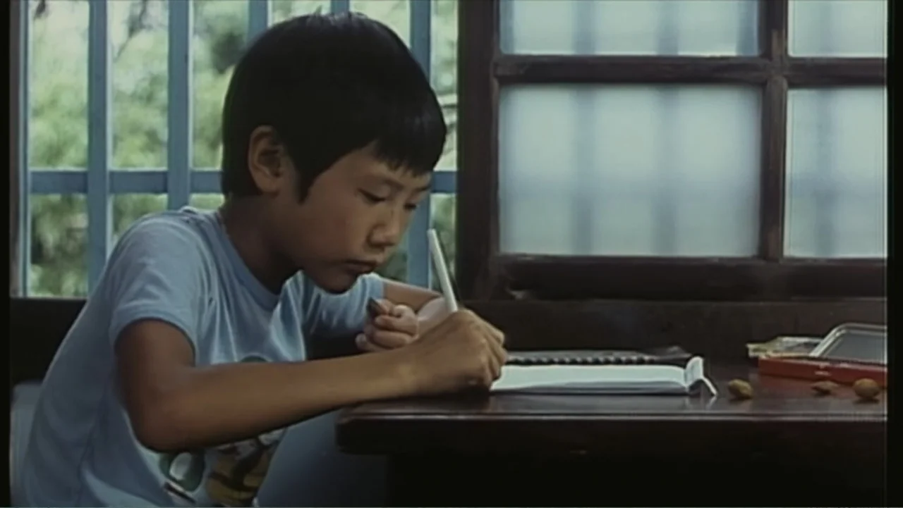 Flowers of Taipei: Taiwan New Cinema (2014) movie still: medium — An interior space features a wooden desk placed in front of a window. A young boy…