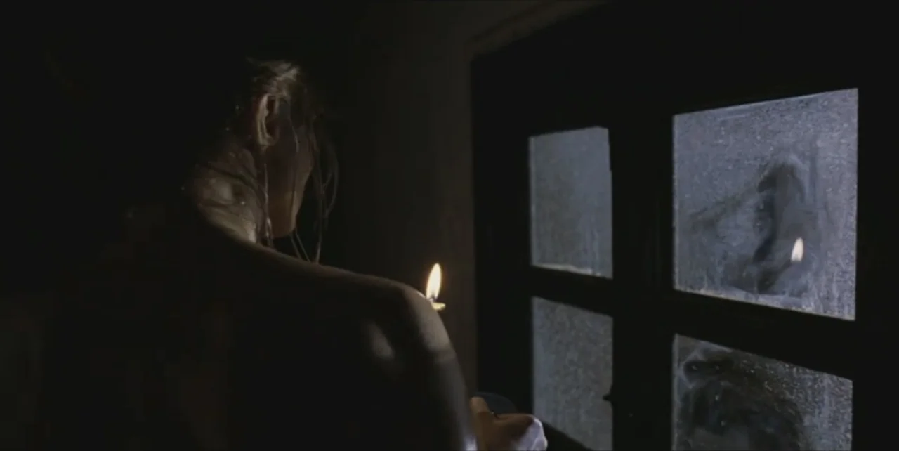 Exorcist: The Beginning (2004) movie still: medium — A dark room with a window showing frosted glass against a black night exterior. A person stands…
