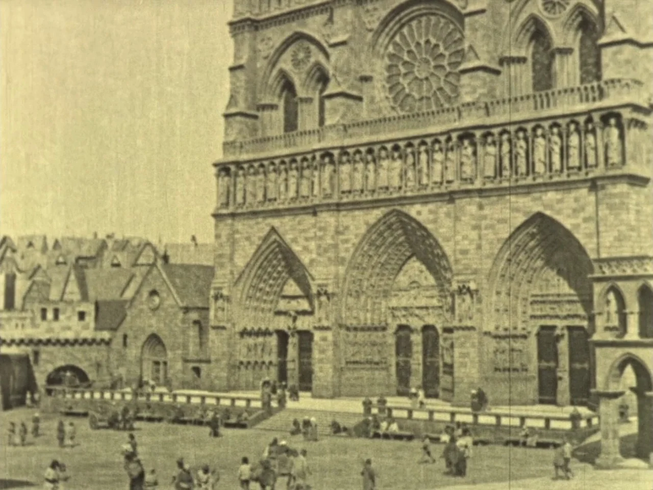 The Hunchback of Notre Dame (1923) movie still: establishing — A stone cathedral with a large rose window dominates the center of the frame.…