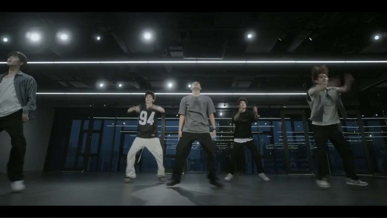 Lee Soo Man: King of K-Pop (2025) movie still: fullbody — A spacious dance studio at night features large floor-to-ceiling windows overlooking a…