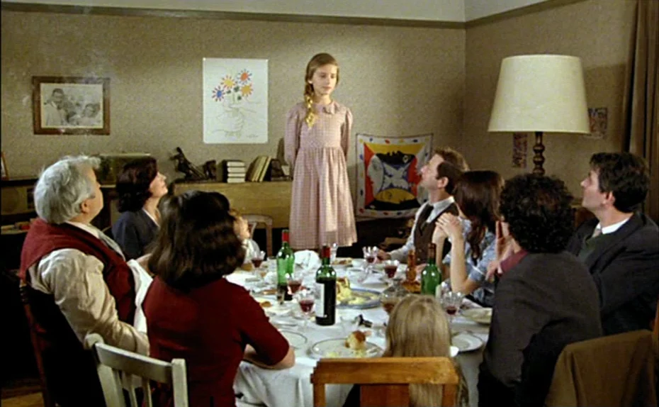 My American Uncle (Mon oncle d’Amérique) (1980) movie still: wide — A group of adults and children sit around a dining table in a mid-century room.…