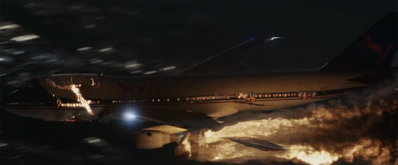 Final Destination 5 (2011) movie still: wide — A large commercial jetliner flies through the night sky with its fuselage and wing engulfed in…