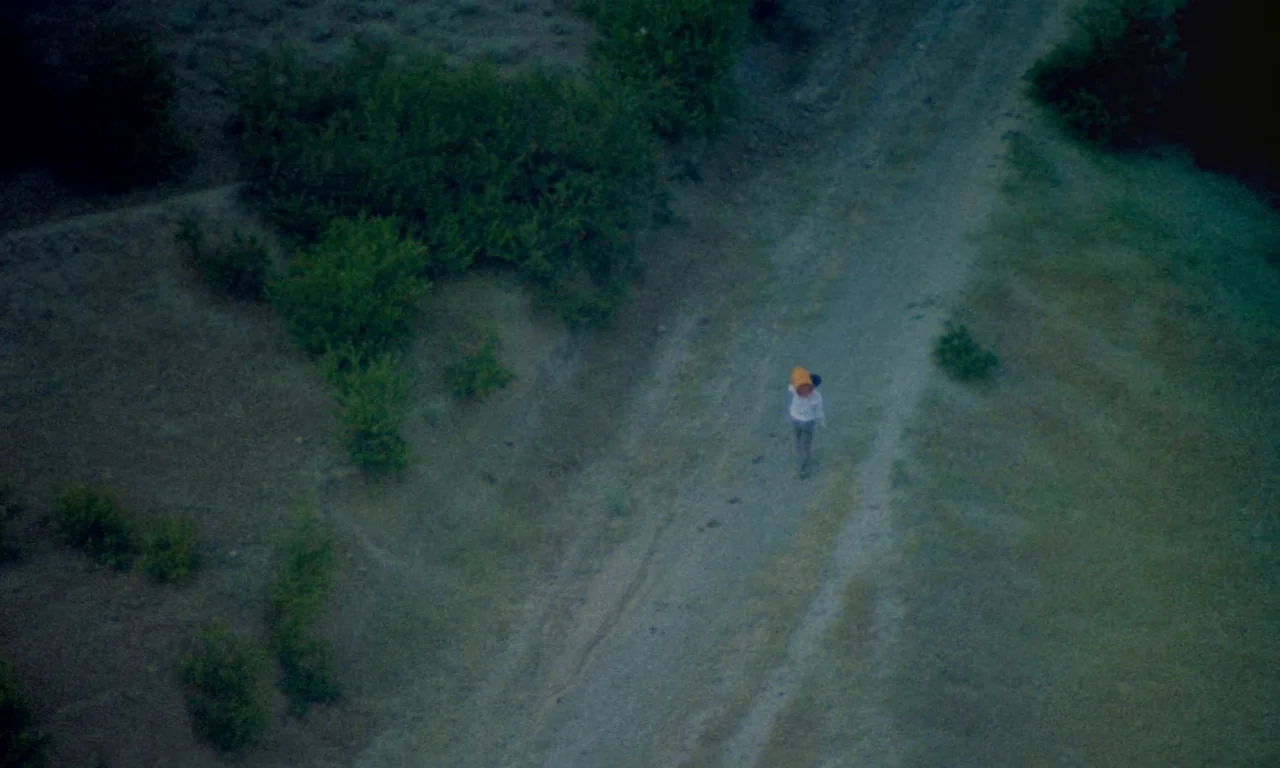 Life, and Nothing More (1992) movie still: establishing — A dry, grass-covered rural landscape features a narrow dirt track running through the…