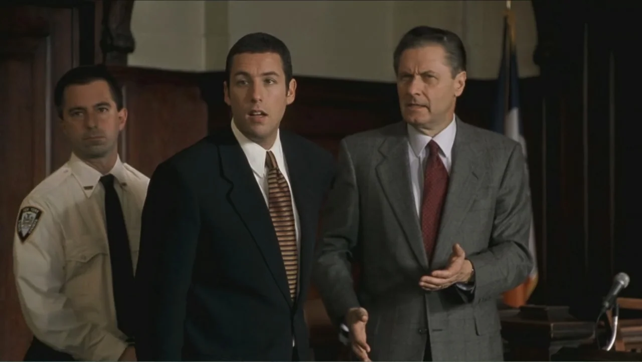 Big Daddy (1999) movie still: medium — A wood-paneled courtroom features dim lighting and formal attire for the participants. Three men stand in the…