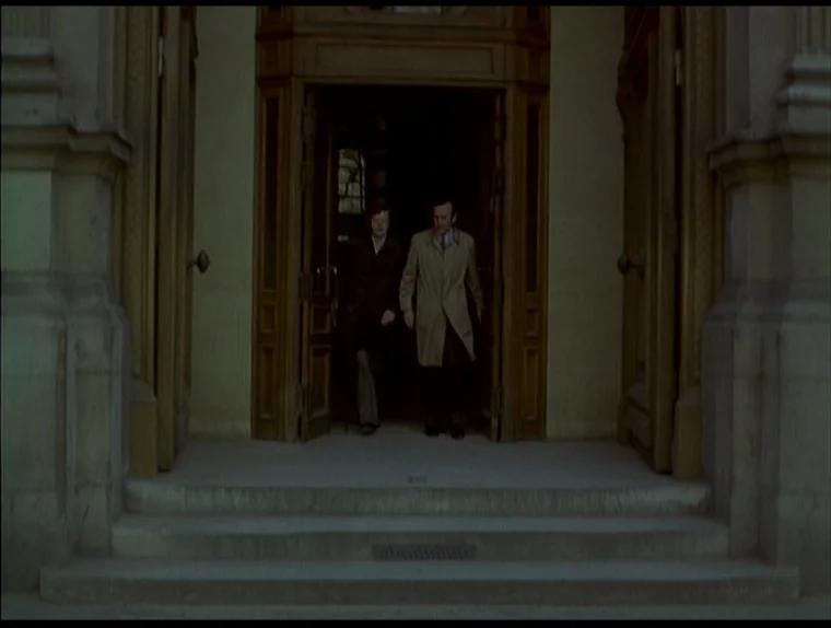 Love In The Afternoon (Chloe In The Afternoon) (L’amour l’après-midi) (1972) movie still: fullbody — A stone building entrance features tall wooden…
