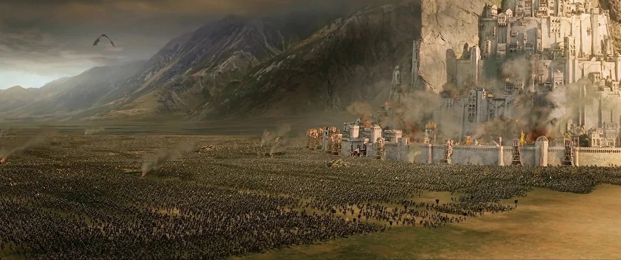 The Lord of the Rings: The Fellowship of the Ring (2001) movie still: establishing — A vast medieval stone fortress stands against a mountain range…