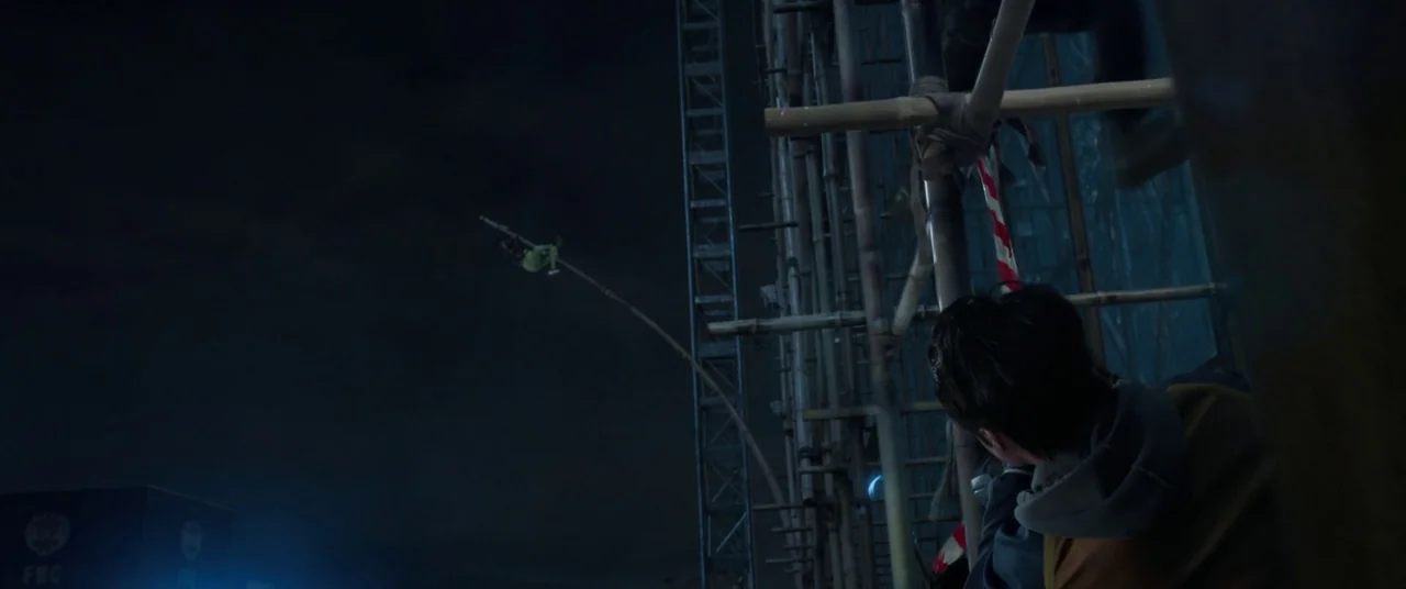 Shang-Chi and the Legend of the Ten Rings (2021) movie still: wide — A night exterior showing bamboo scaffolding against a dark sky with a blue…