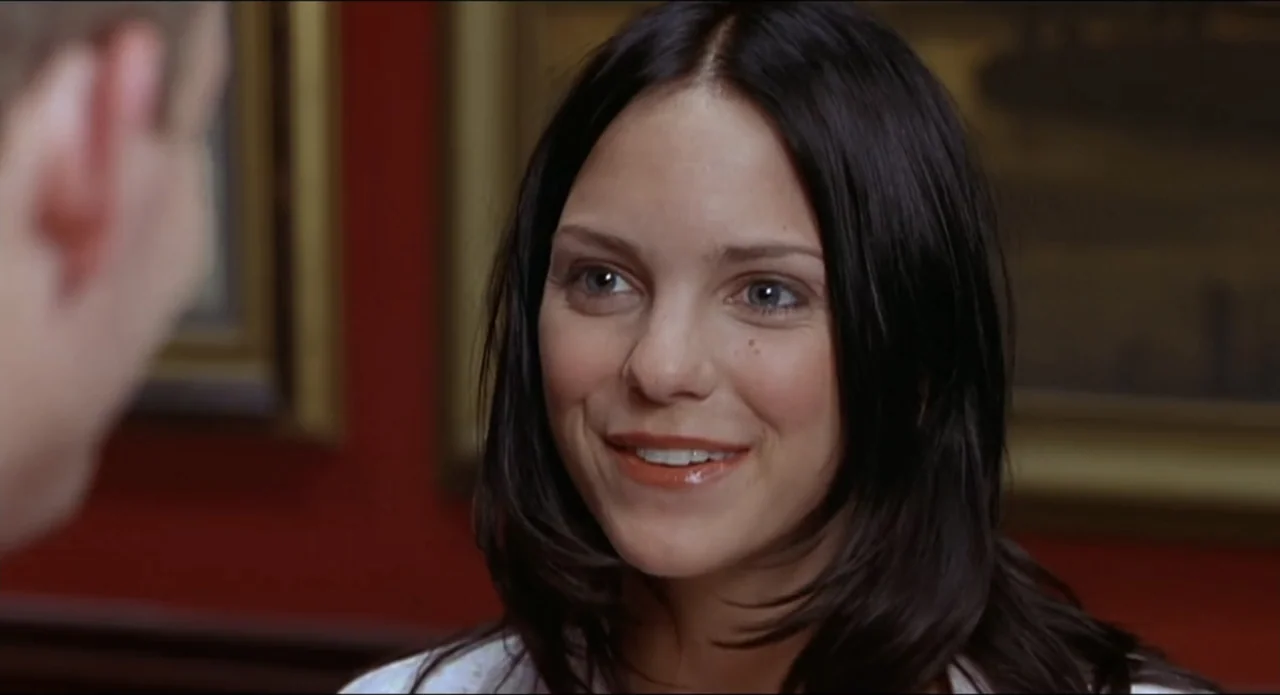 Scary Movie 2 (2001) movie still: closeup — A dark red office interior features framed pictures on the wall behind the subject. A young woman with…