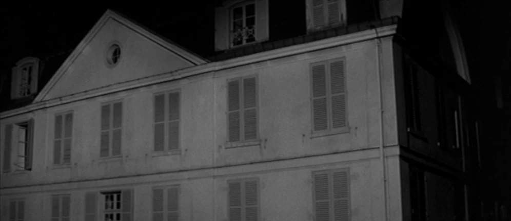 Les Amants (1958) movie still: establishing — A two-story French manor with symmetrical shuttered windows sits at night. The structure is…