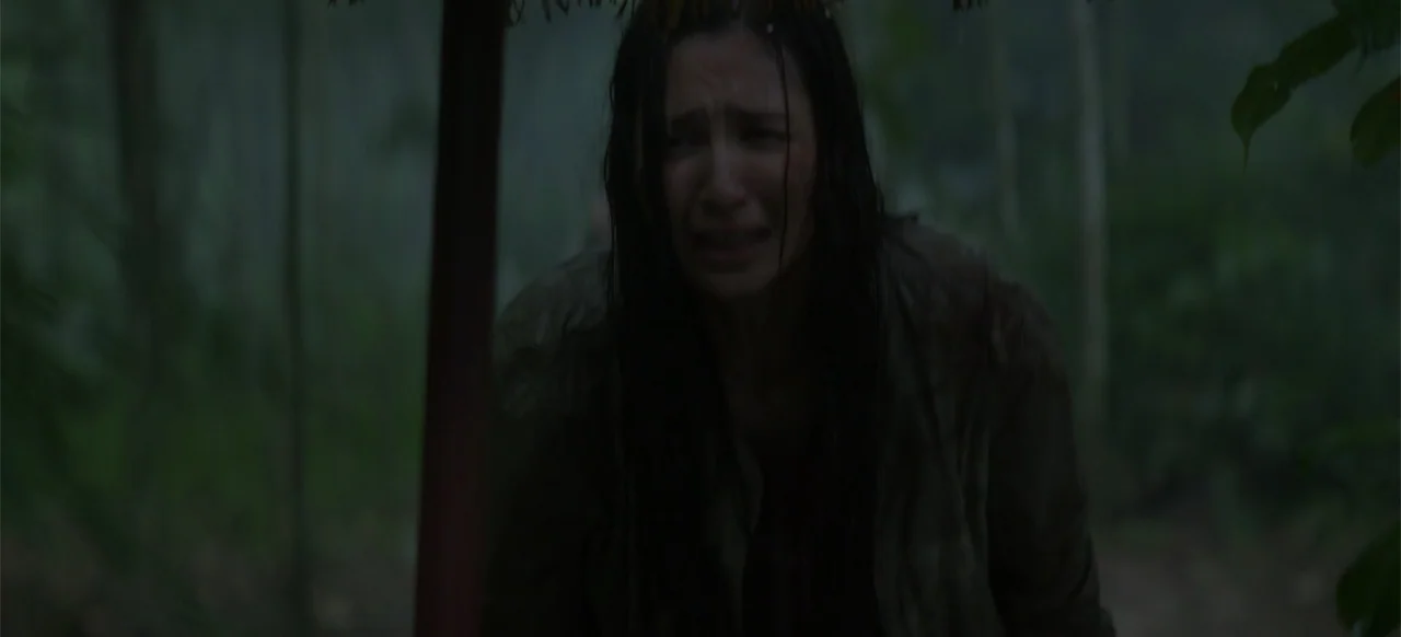 A Thousand Days (2023) movie still: medium — A dense humid tropical jungle environment with thick vegetation and raining conditions. A young woman…