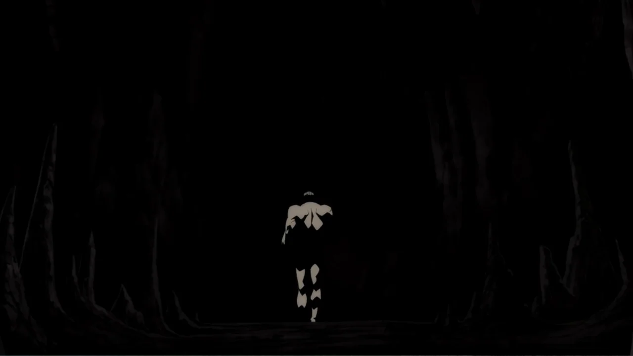 Batman: The Dark Knight Returns, Part 1 (2012) movie still: wide — A dark subterranean cave with jagged stone formations lining the walls. A lone…