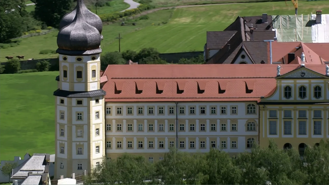 The Alps from Above: Symphony of Summits (2014) movie still: wide — A large multi-story monastery complex features a prominent onion-domed tower and…