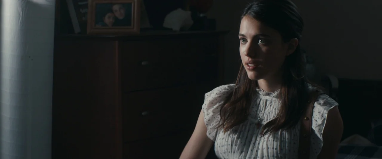 Strange but True (2019) movie still: medium — A dark bedroom features a wooden dresser with a picture frame in the background. A young woman in a…