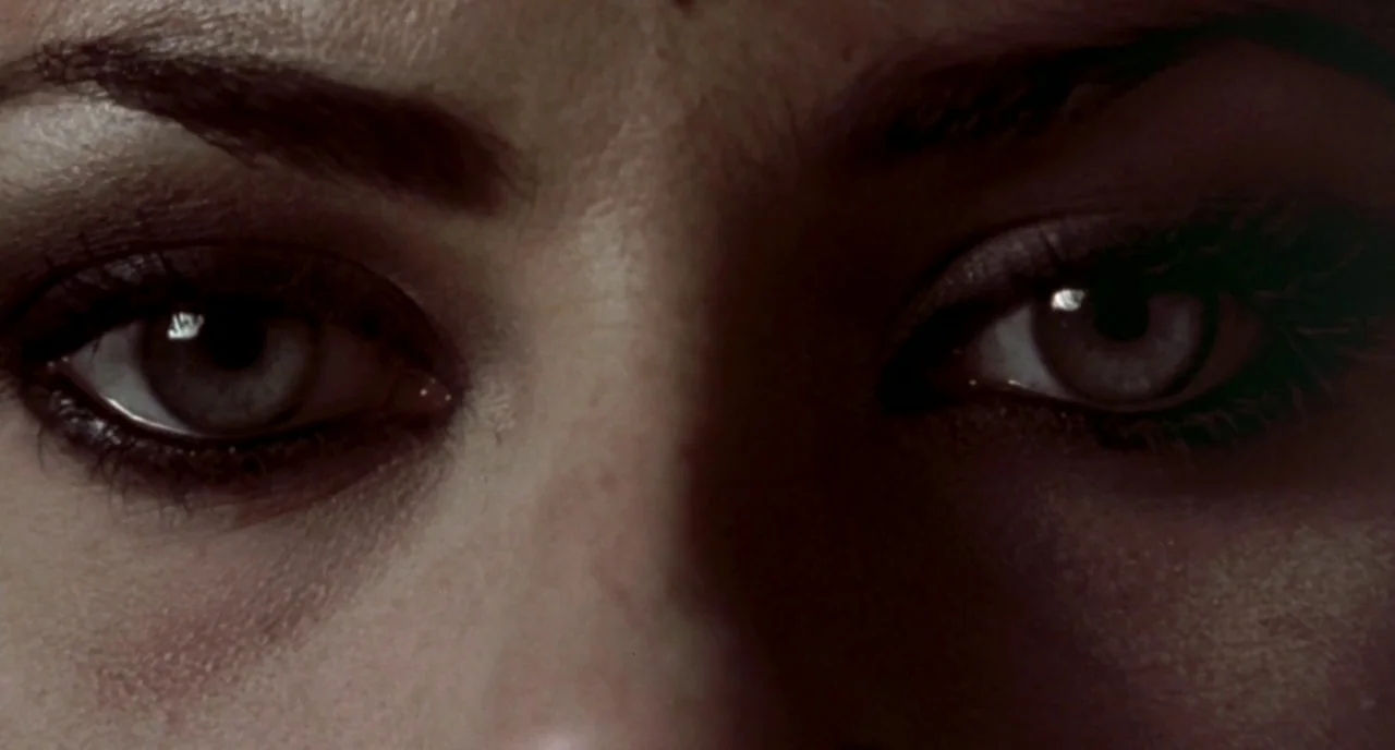 The Craft (1996) movie still: closeup — An extreme close-up view focuses on a pair of human eyes. The subject gazes directly forward from a dark and…