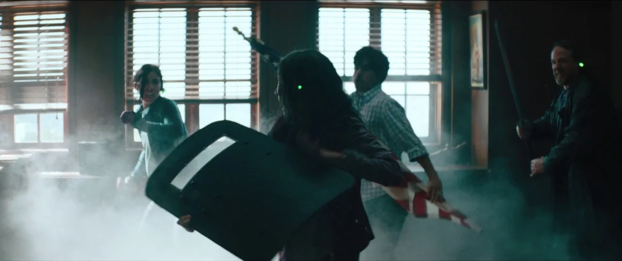 Everything Everywhere All At Once (2022) movie still: wide — A smoke-filled room with large windows features four people moving through the space.…