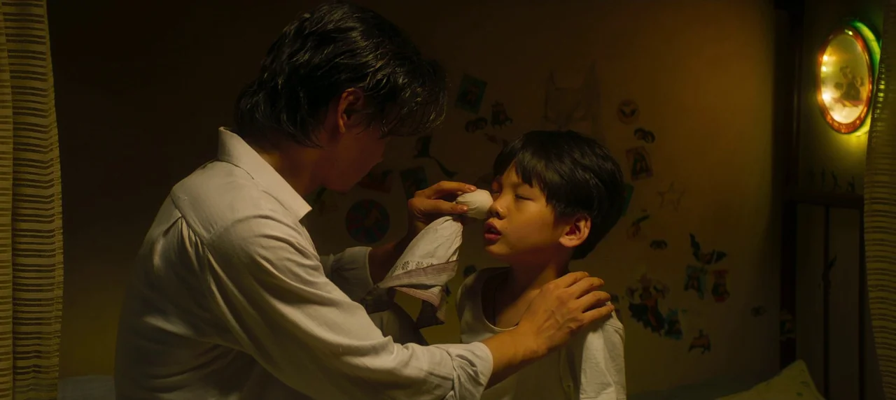 Master Z: The Ip Man Legacy (2018) movie still: medium — A dimly lit room features walls decorated with numerous small paper cutouts and stickers. A…