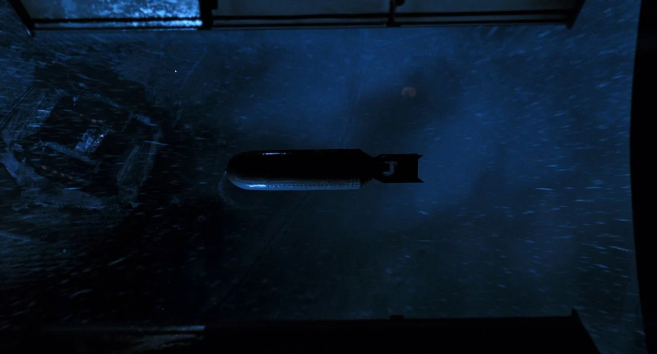 The Devils Backbone (2001) movie still: wide — A metal munition drops through the dark, rainy night sky at a high altitude. The object is framed…