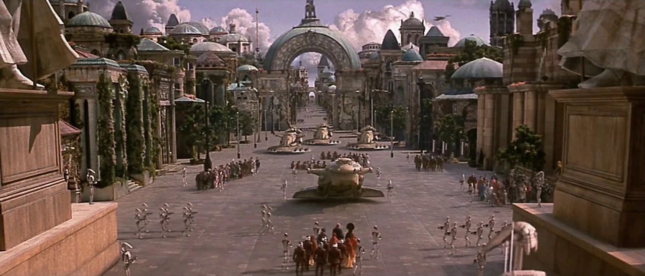 Star Wars: Episode I – The Phantom Menace (1999) movie still: establishing — A sprawling sunlit plaza is lined with ornate statues and…
