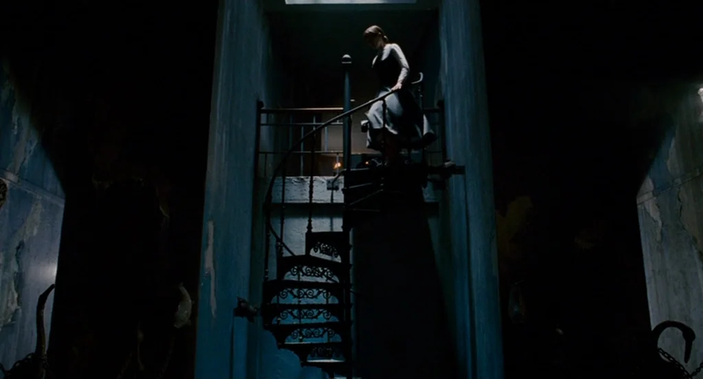Fur: An Imaginary Portrait Of Diane Arbus (2006) movie still: fullbody — An ornate cast-iron spiral staircase sits in a dark, vaulted stone space. A…