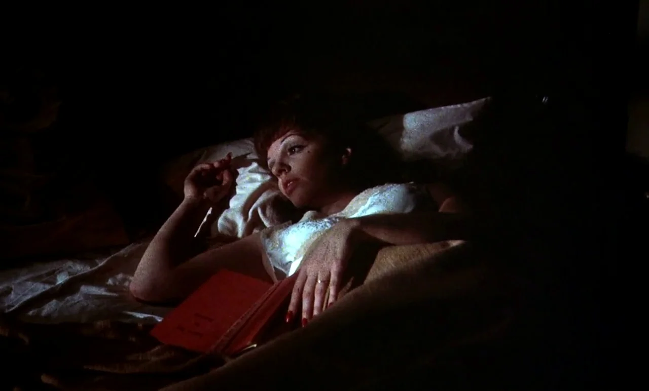 New York, New York (1977) movie still: medium — A dim room at night with a woman resting on white bed linens. The woman lies partially under covers…
