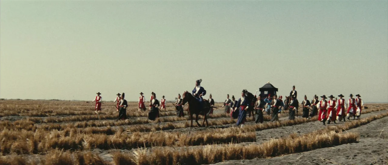 A Touch of Zen (1971) movie still: wide — A group of men in traditional historical attire walks across a vast, barren field. One man rides a brown…