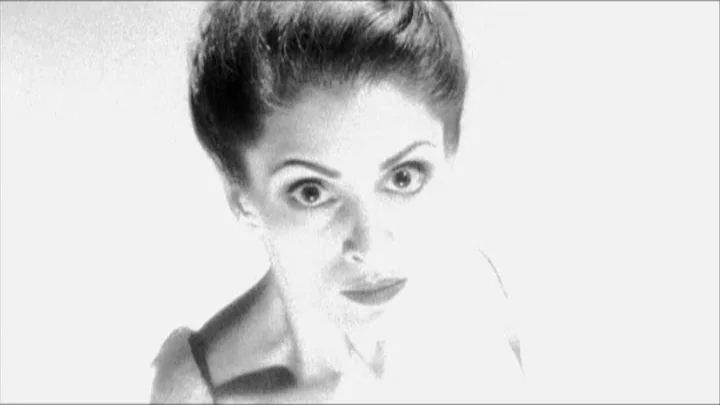 Dracula: Pages from a Virgin’s Diary (2002) movie still: closeup — A woman looks toward the camera against an intensely overexposed white…