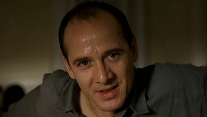 Funny Games (1997) movie still: closeup — An interior dimly lit room provides a blurred, indistinct background for the subject. A middle-aged man…