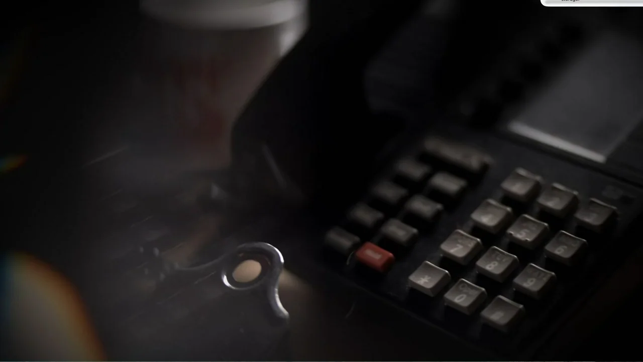 Murder at Carter County Mines (2023) movie still: closeup — A close-up view of a dark office desk surface during the night. A black desktop…
