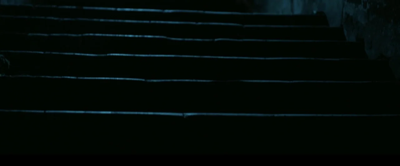 The Chanting 3 (2008) movie still: establishing — A set of dark stairs ascends into shadow with faint blue light on edges. No subjects are present…