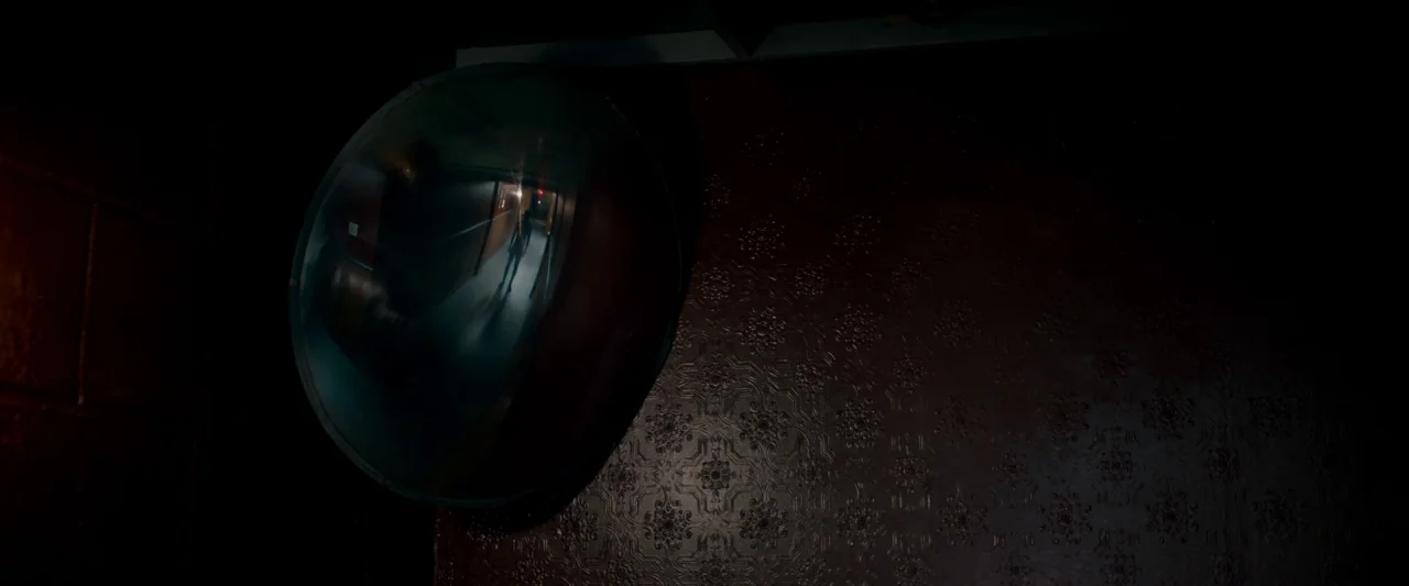 The Autopsy of Jane Doe (2016) movie still: medium — A dark, interior wall features embossed floral-pattern wallpaper with a large convex security…