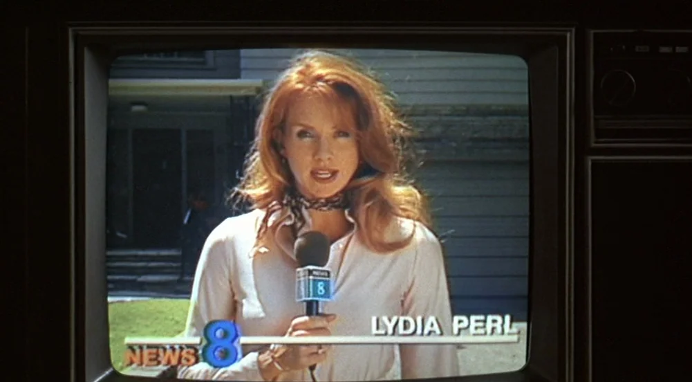 The Virgin Suicides (1999) movie still: medium — A woman is shown on a CRT television screen during a news broadcast report. She holds a News 8…