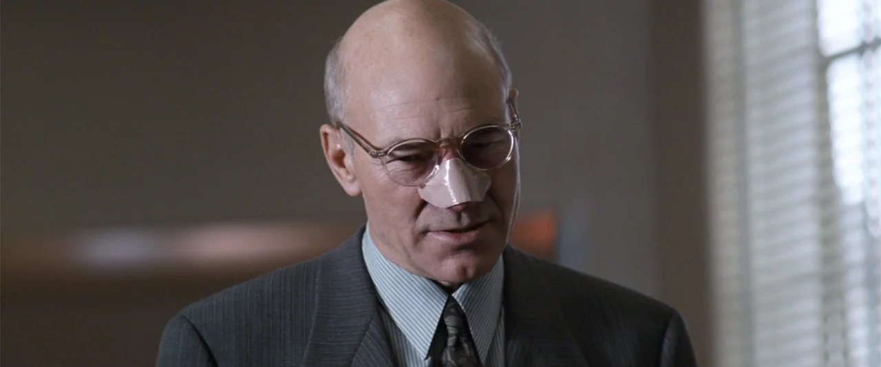 Conspiracy Theory (1997) movie still: closeup — A professional office environment featuring muted tones and blurred background elements near a…