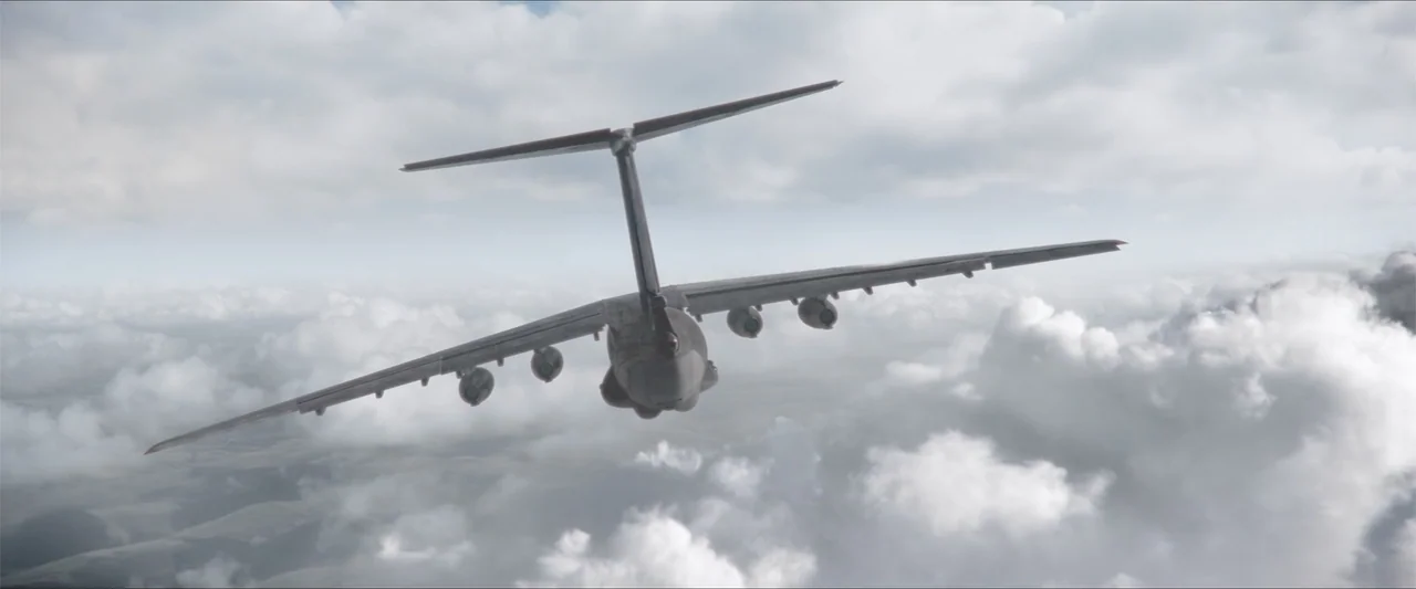 Heads of State (2025) movie still: wide — A military transport aircraft cruises at high altitude above a solid layer of white clouds. The plane is…