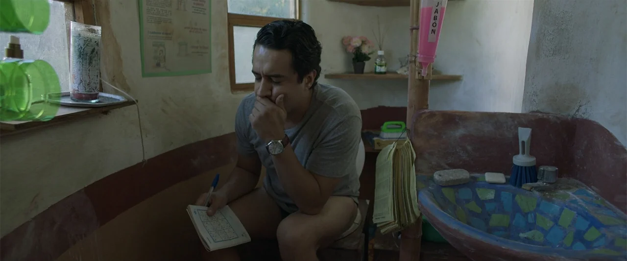Mirreyes contra Godínez 2: El retiro (2022) movie still: medium — A small rustic restroom with textured walls and a tiled handmade sink. A man in a…