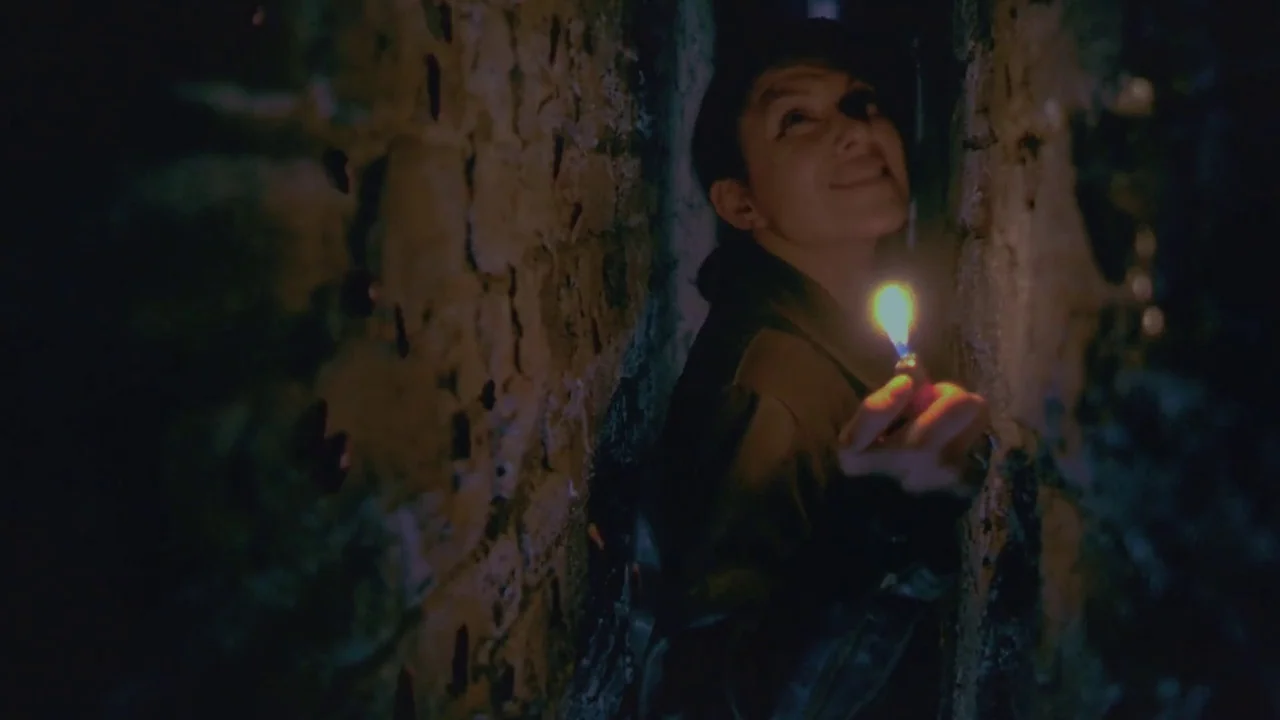 Hellraiser: Deader (2005) movie still: medium — A person stands within a claustrophobic, narrow passage formed by rough, uneven masonry walls. The…
