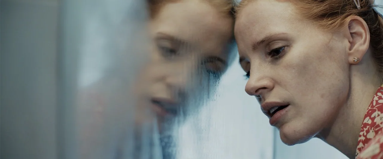 The 355 (2022) movie still: closeup — A tiled bathroom space features a glass partition coated in thick condensation and water droplets. A woman…