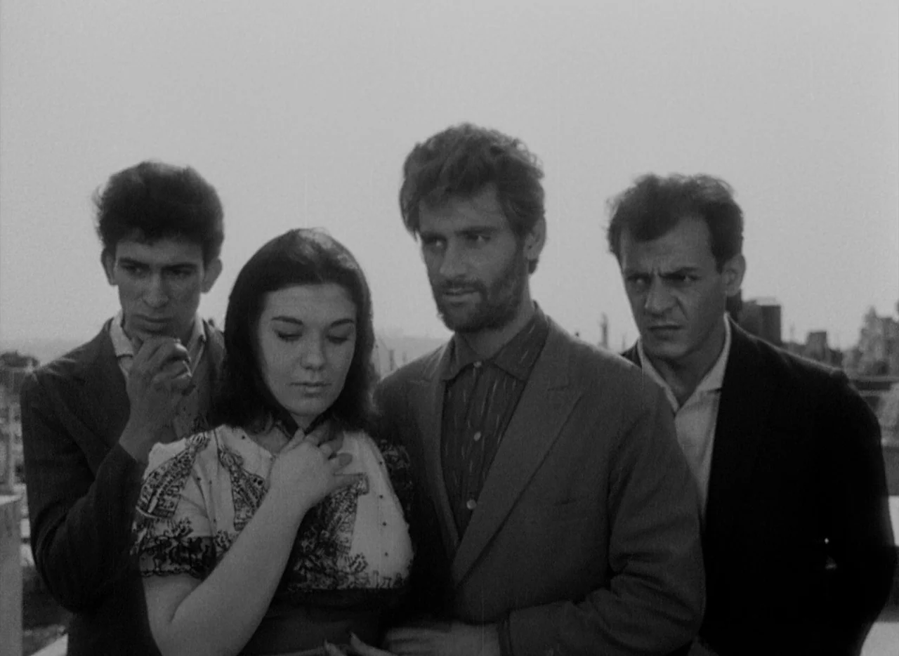 At Midnight I’ll Take Your Soul (1964) movie still: medium — Four young adults gather closely together on a rooftop under a bright overcast sky. The…