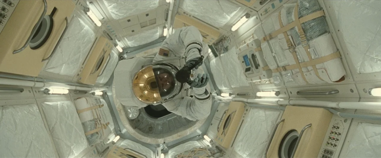 Ad Astra (2019) movie still: medium — A high-tech spacecraft cabin features padded modular walls and recessed lighting panels. An astronaut in a…