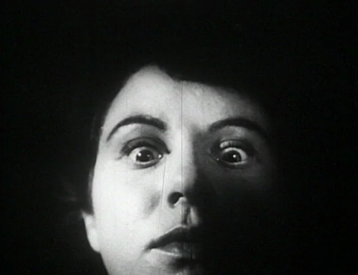 Dementia (Daughter of Horror) (1955) movie still: closeup — A close-up shot showing only the subject's face emerging from a black background. The…