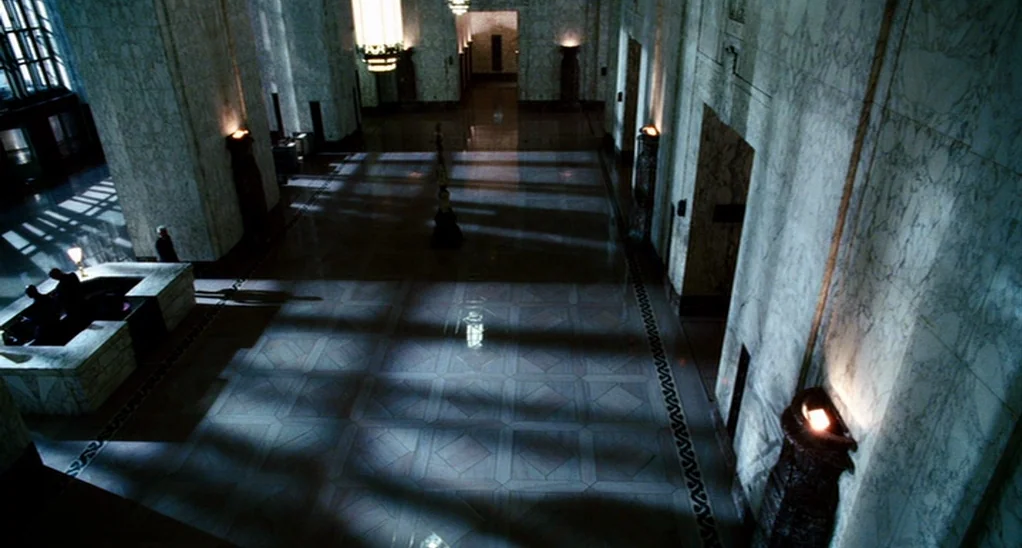 The Adjustment Bureau (2013) movie still: wide — A grand art deco lobby features polished marble walls, floors, and massive stone pillars. Long,…