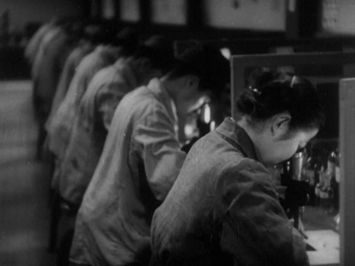 The Most Beautiful (1944) movie still: medium — A laboratory row features several individuals working diligently at individual stations with…