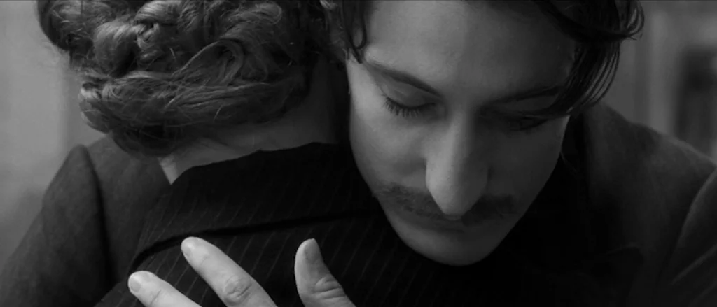 Frantz (2016) movie still: closeup — The frame captures two people in a close embrace. The man looks down while pressing his cheek against the woman.