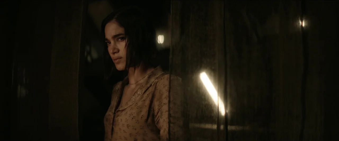 Rebel Moon – Part One: A Child of Fire (2023) movie still: medium — A dimly lit room with a hanging mesh curtain obscuring part of the view. A woman…
