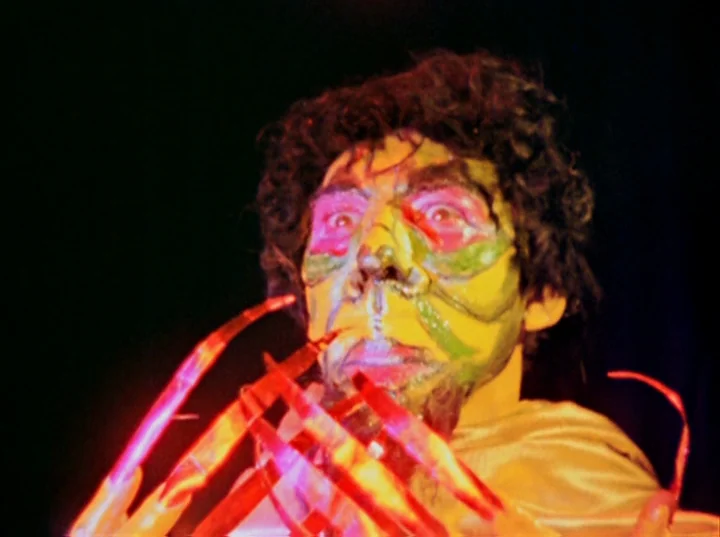 Inauguration of the Pleasure Dome (1954) movie still: closeup — A person with elaborate theatrical makeup is positioned against a solid black…