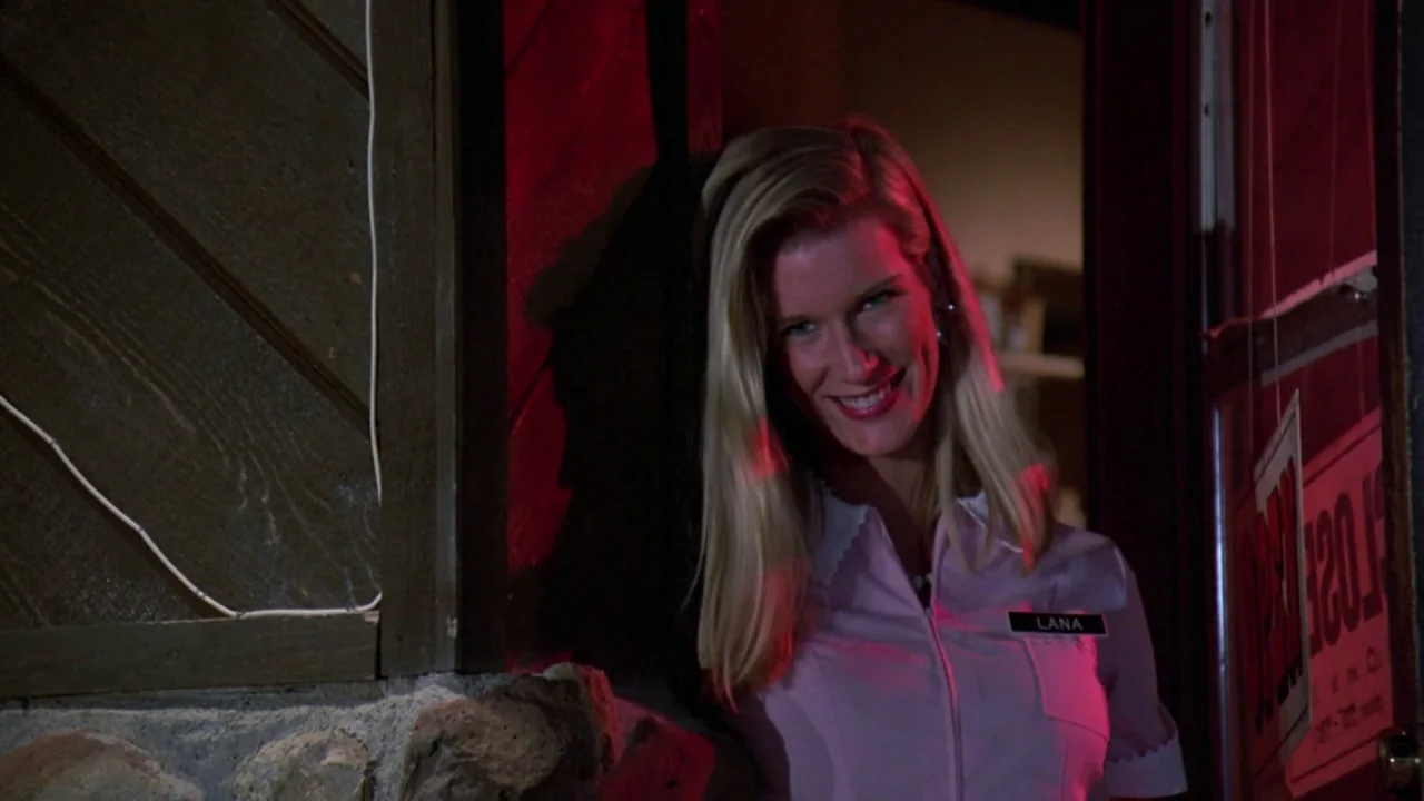 Friday the 13th: A New Beginning (1985) movie still: medium — A woman stands in the doorway of a diner at night under red lighting. She looks toward…