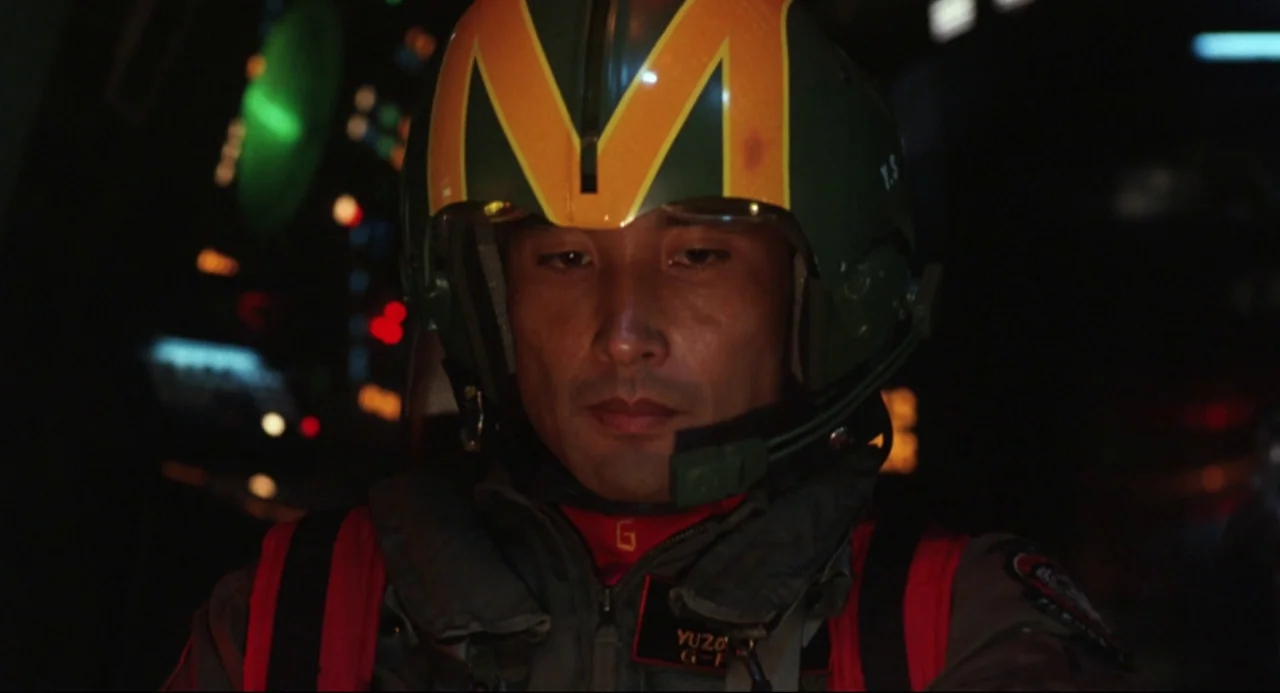 Godzilla vs. SpaceGodzilla (1994) movie still: closeup — A dimly lit cockpit interior with blurred instrument panels visible in the background. A…