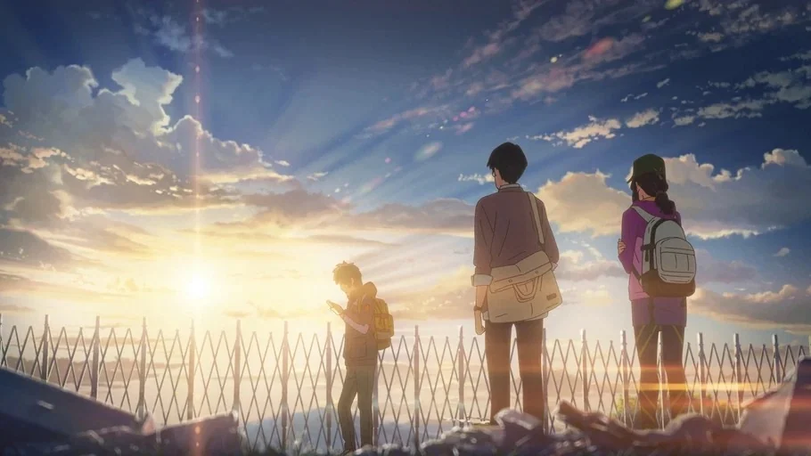 Your Name (2016) movie still: wide — An elevated platform with a white metal fence overlooks a wide valley at sunset. Three people stand silhouetted…